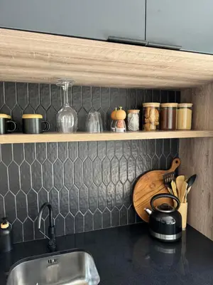 a kitchen with a sink and a shelf with pots and pans at Little Heaven in Cape Town