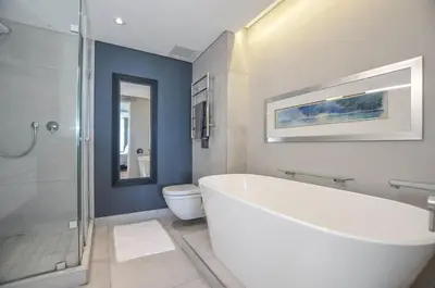 a bathroom with a tub and a shower and a toilet at Stylish Apartment with Ocean Views - Dolphin Beach in Cape Town