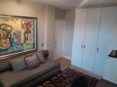 a living room with a couch and a painting on the wall at Stylish Apartment with Ocean Views - Dolphin Beach in Cape Town