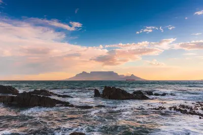 a view of the ocean with a mountain in the background at Studio Apartment - Dolphin Beach in Cape Town
