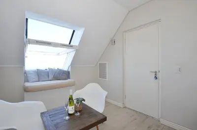 a white room with a table and a window at Studio Apartment - Dolphin Beach in Cape Town