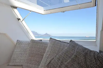 a group of pillows sitting in front of a window at Studio Apartment - Dolphin Beach in Cape Town