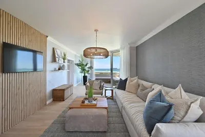 a living room with a couch and a tv at 3 Bedroom Cabana on the Beach in Cape Town