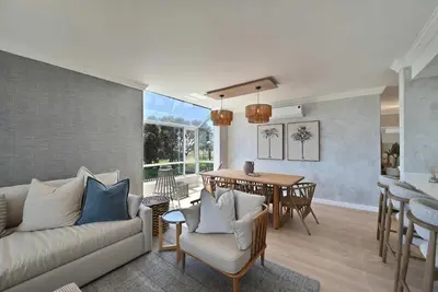 a living room with a couch and a table at 3 Bedroom Cabana on the Beach in Cape Town