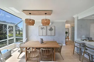 a dining room with a wooden table and chairs at 3 Bedroom Cabana on the Beach in Cape Town