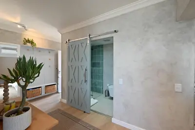 a bathroom with a shower with a glass door at 3 Bedroom Cabana on the Beach in Cape Town