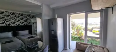 a bedroom with a bed and a sliding glass door at Studio Kiters Room - Dolphin Beach in Cape Town