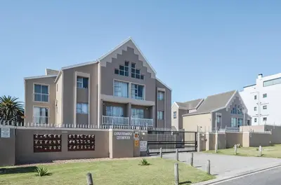 an apartment building with a fence in front of it at Modern 1 Bedroom Apartment in Blouberg in Cape Town