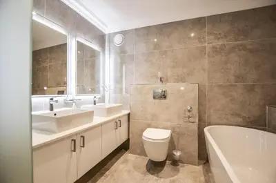 a bathroom with two sinks and a toilet and a tub at Modern 2 Bedroom Apartment At Dolphin Beach in Cape Town