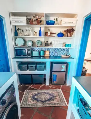 a kitchen with blue and white dishes on shelves at Amulet At The Sea in Hermanus
