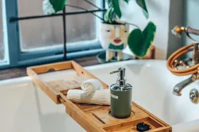 a bathroom sink with a wooden tray with a faucet at Amulet At The Sea in Hermanus
