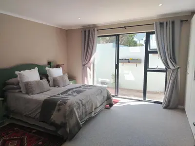 a bedroom with a bed and a large sliding glass door at Columbus Whales in Hermanus