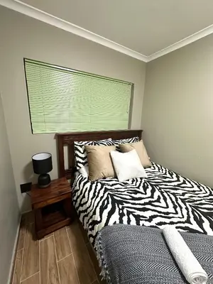 a zebra print bed in a bedroom with a window at 29 Windsor Flatlet 2 in Silver Sands