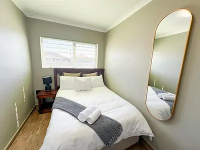 a bedroom with a bed with a large mirror at 29 Windsor Flatlet 2 in Silver Sands