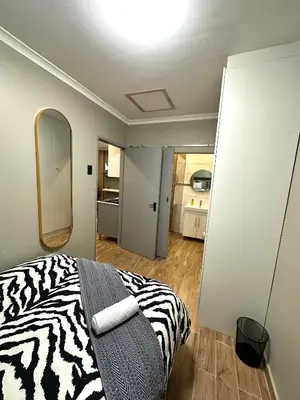 a zebra print bed in a room with a mirror at 29 Windsor Flatlet 2 in Silver Sands