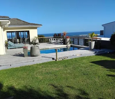 a house with a deck and a swimming pool at Chanteclair Holiday Home in Hermanus