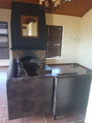 a leather couch in a living room with a fireplace at 4 th On Boundary in Gordonʼs Bay