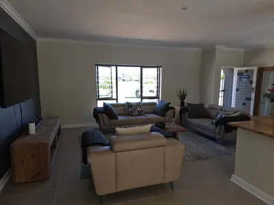 a living room with two couches and a table at Dolphin Paradise in Cape Town