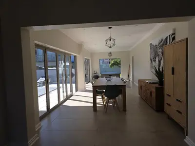 a dining room with a table and glass doors at Dolphin Paradise in Cape Town