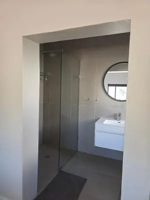 a bathroom with a shower and a sink and a mirror at Dolphin Paradise in Cape Town