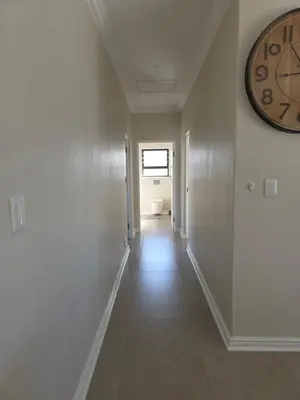 an empty hallway with a clock on the wall at Dolphin Paradise in Cape Town