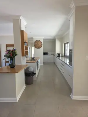 a large kitchen with white cabinets and a counter at Dolphin Paradise in Cape Town