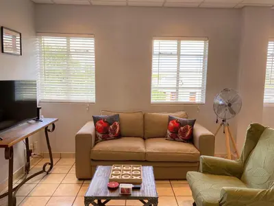 a living room with a couch and a table at Granaat Pit - Paarl - Self Catering Apartment in Paarl