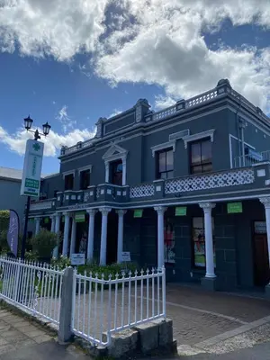 a blue building with a white fence in front of it at Granaat Pit - Paarl - Self Catering Apartment in Paarl