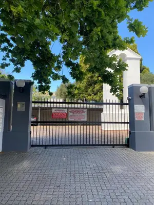 a black fence with a sign on top of it at Granaat Pit - Paarl - Self Catering Apartment in Paarl