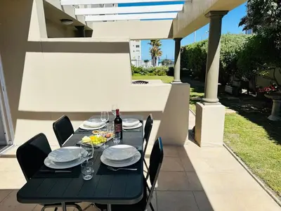 a black table with plates and wine glasses on a patio at Seaside Serenity in Cape Town