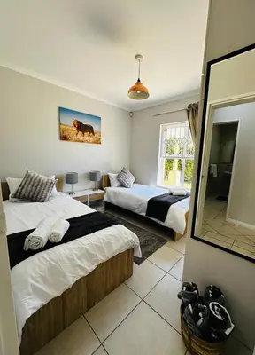 a bedroom with two beds and a mirror at Seaside Serenity in Cape Town