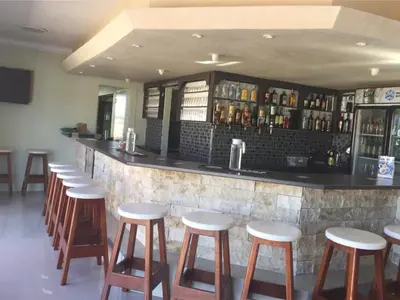 a bar with a row of stools in a restaurant at 258 Hermanus Beach club in Hermanus