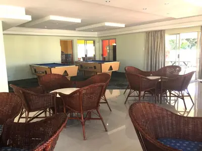 a room filled with chairs and tables and windows at 258 Hermanus Beach club in Hermanus