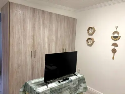 a flat screen tv sitting on top of a table at Private Flatlet B in Goodwood