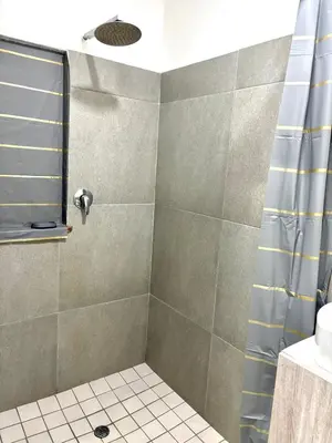 a bathroom with a shower with a blue shower curtain at Private Flatlet B in Goodwood