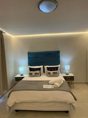 a bedroom with a bed with a blue headboard at Ocean Whisper Room 6 minutes away from the beach in Cape Town