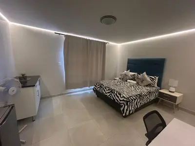 a bedroom with a bed with two cats on it at Ocean Whisper Room 6 minutes away from the beach in Cape Town