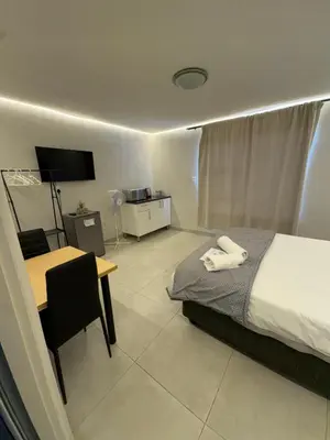 a bedroom with a bed and a table and a desk at Ocean Whisper Room 6 minutes away from the beach in Cape Town