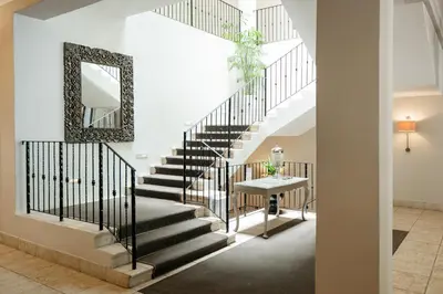 a staircase in a house with a mirror and a table at Le Franschhoek Hotel & Spa by Dream Resorts in Franschhoek
