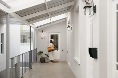 a woman standing at the door of a house at Dorpshuis Apartment, Main Street, Paarl in Paarl