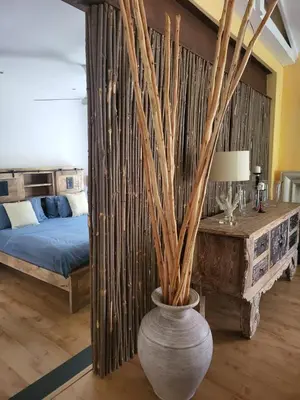 a bedroom with a bed and a vase with trees at Apricot Gardens Guesthouse in Gordonʼs Bay