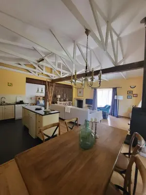 a dining room and kitchen with a wooden table at Apricot Gardens Guesthouse in Gordonʼs Bay