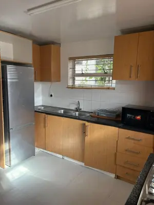 a kitchen with wooden cabinets and a stainless steel refrigerator at 2 Elwyn Road