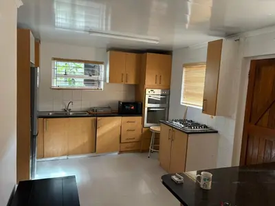 a kitchen with wooden cabinets and a stove top oven at 2 Elwyn Road