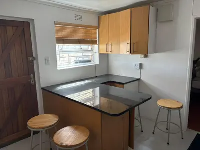 a kitchen with a counter and stools in it at 2 Elwyn Road