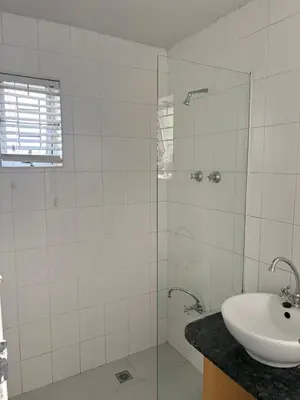 a white bathroom with a sink and a shower at 2 Elwyn Road