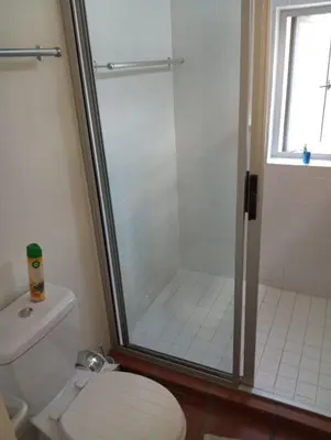 a bathroom with a shower and a toilet with a glass door at Spacious Self-Catering Apartment with Private Entrance in Peaceful Paradyskloof, Stellenbosch in Stellenbosch