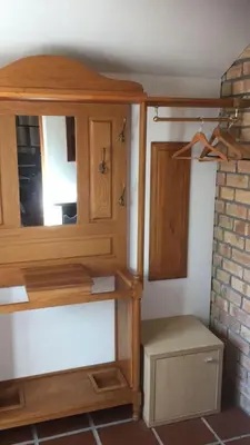 a wooden cabinet in the corner of a room at Spacious Self-Catering Apartment with Private Entrance in Peaceful Paradyskloof, Stellenbosch in Stellenbosch