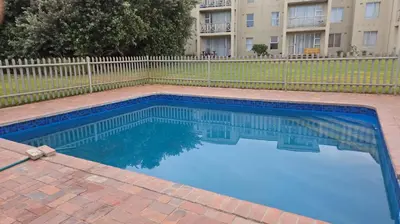 a swimming pool in front of a building at Unit 8 Hermanus Beach Club in Hermanus
