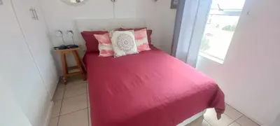 a small bedroom with a pink bed with a window at Unit 169 Hermanus Beach Club in Hermanus